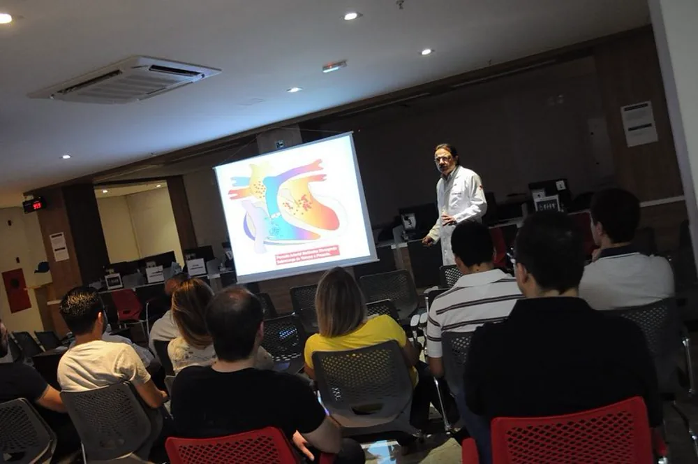 Médico do INCOR apresentando um slide de anatomia cardíaca a uma plateia
