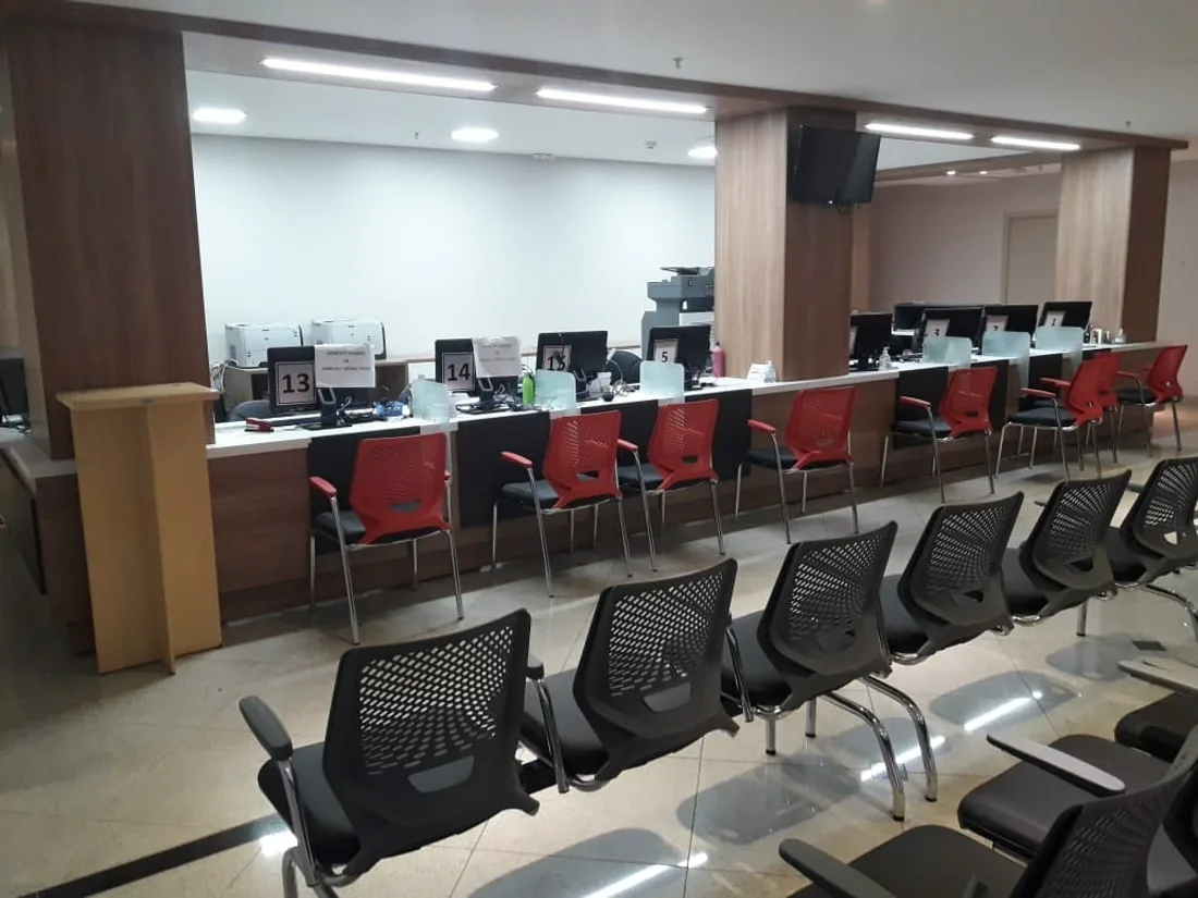 Balcão de atendimento do INCOR Rio Preto, com guichês numerados e cadeiras de espera